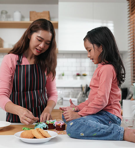 women with her daughter cooking together in the kitchen